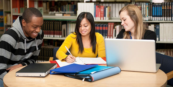 college students studying in a library of books